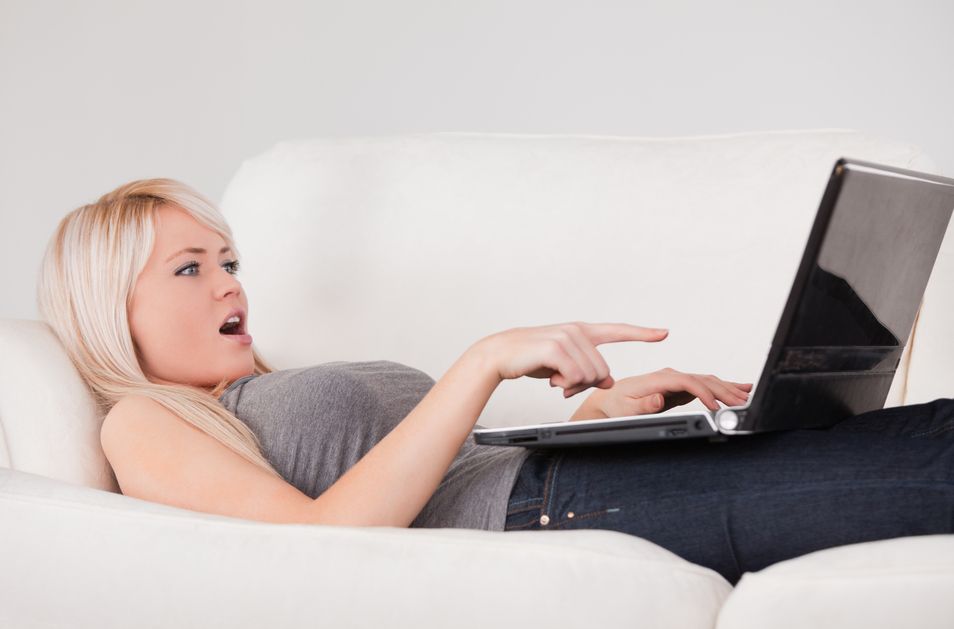 Photodune 8306882 Surprised Woman Relaxing on Laptop Lying on a Sofa S