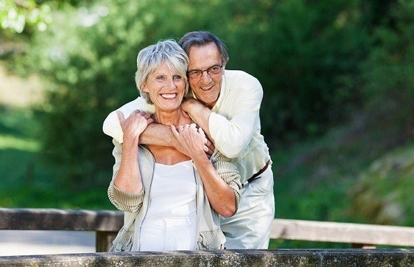 Senior Man Embracing Wife From Behind While Looking Away
